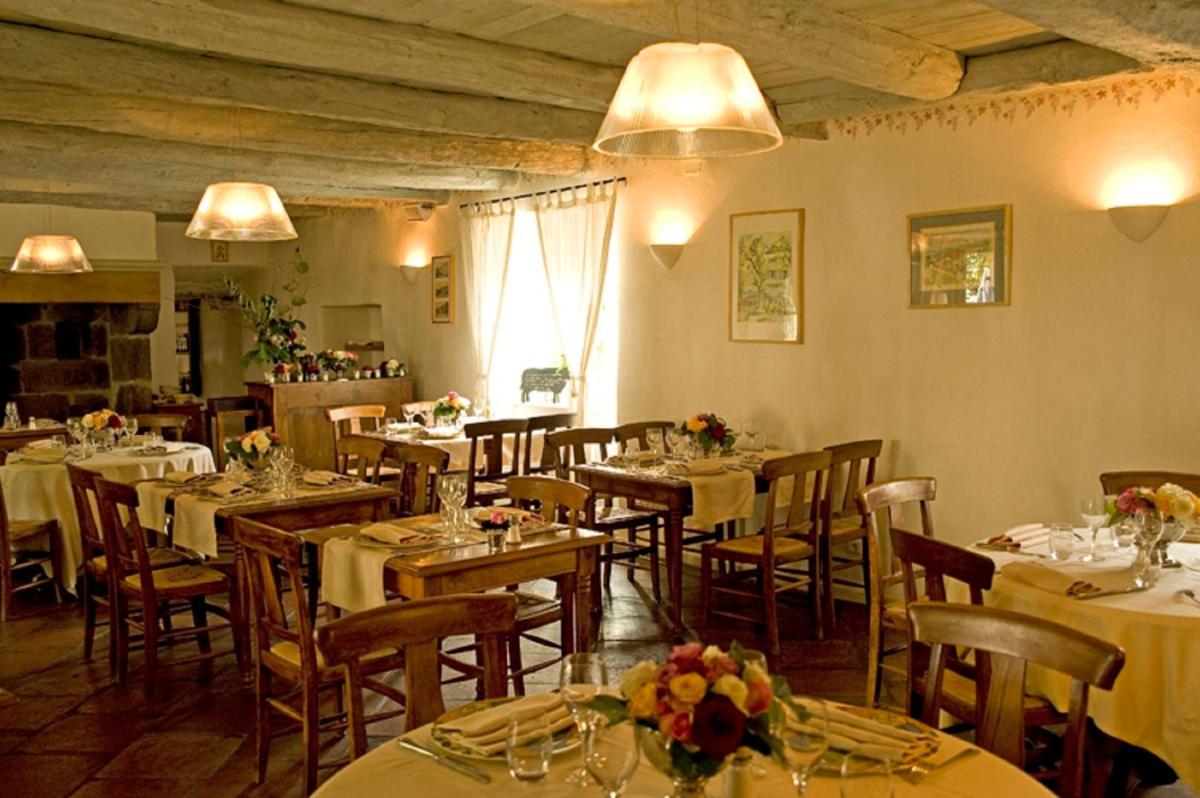 un restaurant avec tables et chaises et nappes blanches dans l'établissement Hotel La Bougnate, à Blesle 31 autres photos