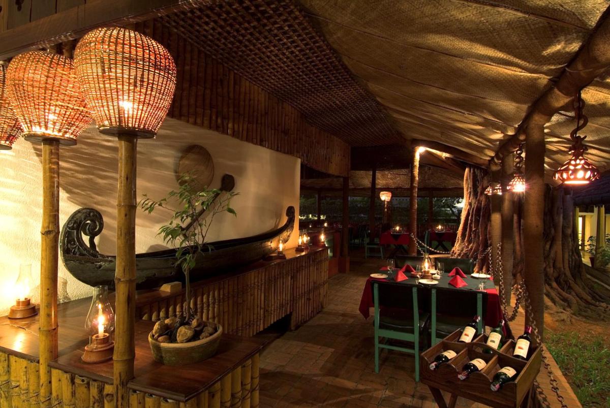a restaurant with a table and a boat on the wall at Casino Hotel - CGH Earth, Cochin in Cochin