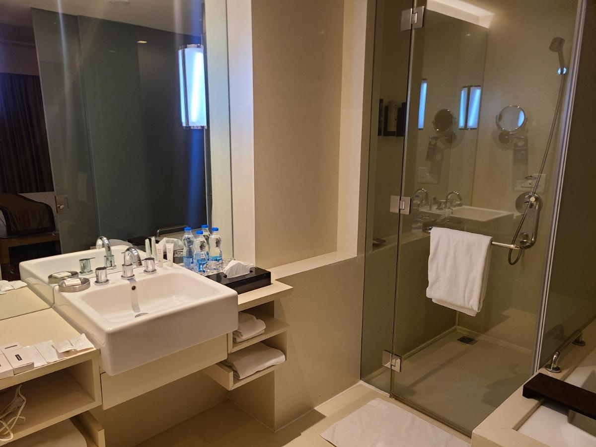 a bathroom with a sink and a shower at Novotel Hyderabad Airport in Hyderabad