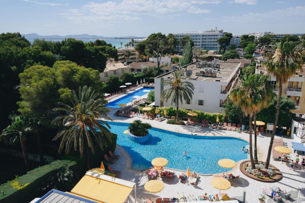 Una vista aérea de una piscina con sombrillas. en Hotel Ivory Playa Sports & Spa, en Puerto de Alcudia