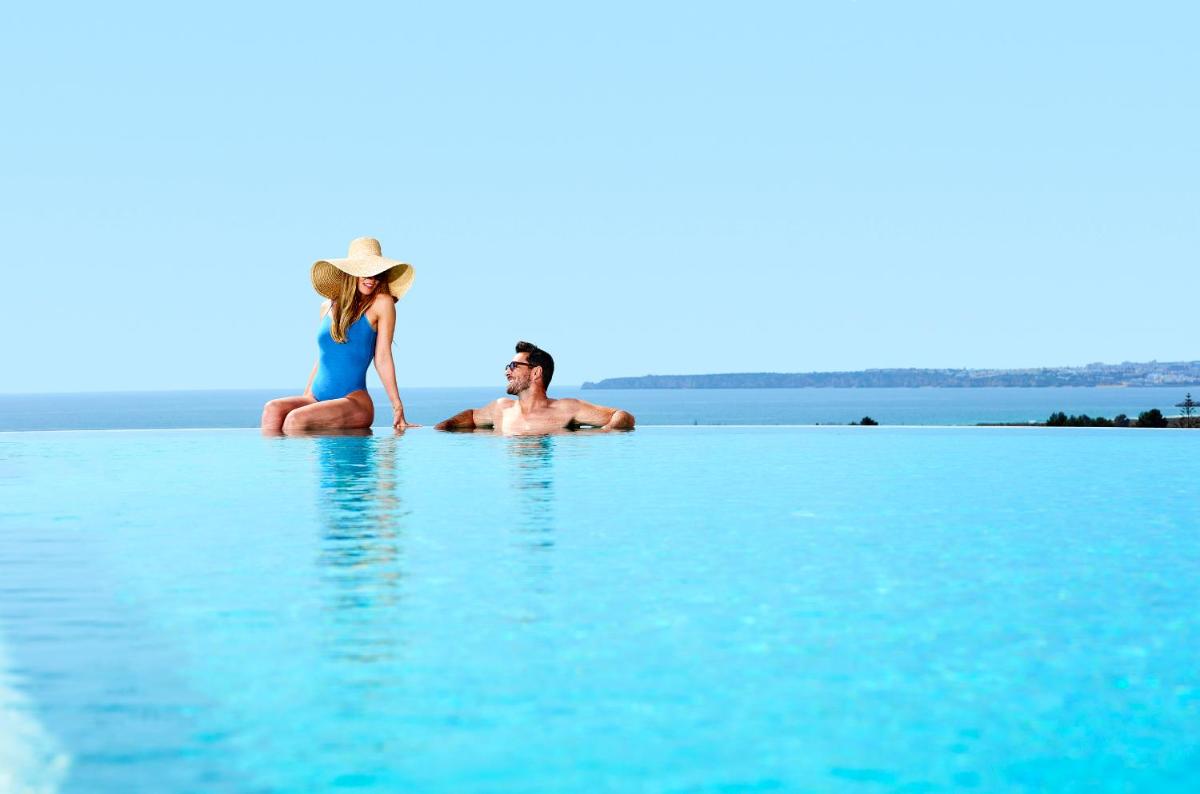um homem e uma mulher sentados na água em Longevity Health & Wellness Hotel - Adults Only em Alvor