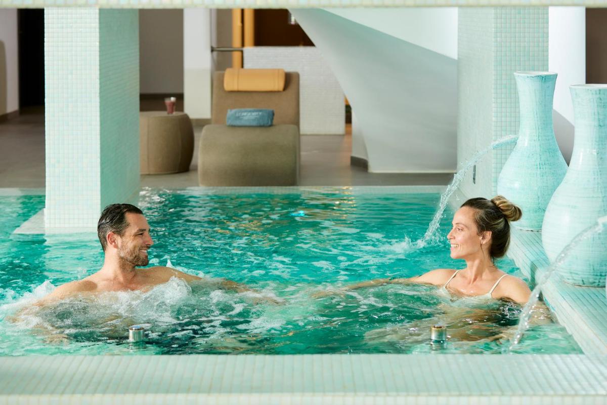 um homem e uma mulher a nadar numa piscina em Longevity Health & Wellness Hotel - Adults Only em Alvor
