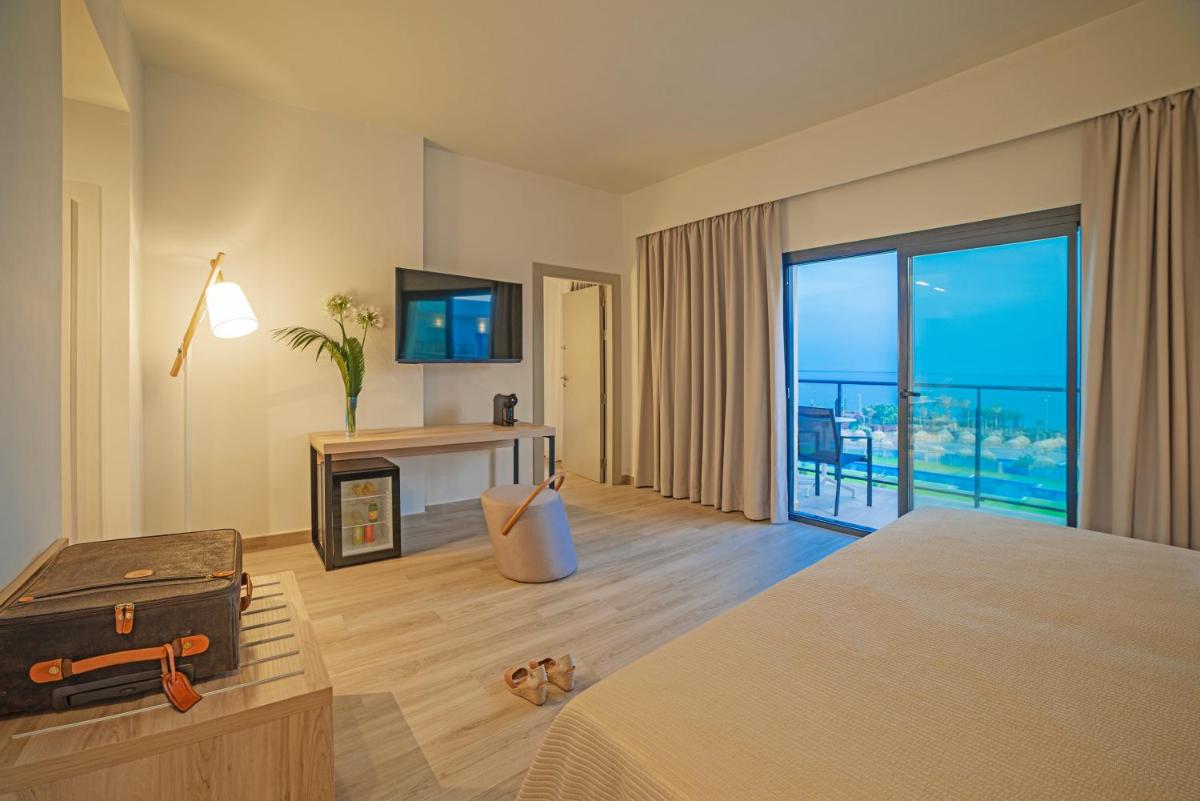 Una habitación de hotel con una cama y vista al océano. en Cabogata Beach Hotel, en Retamar