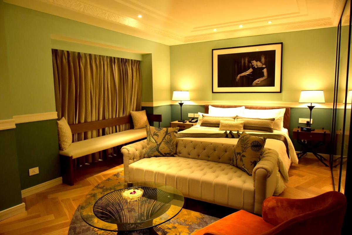 a bedroom with a bed and a couch and a table at Radisson Hotel Shimla in Shimla