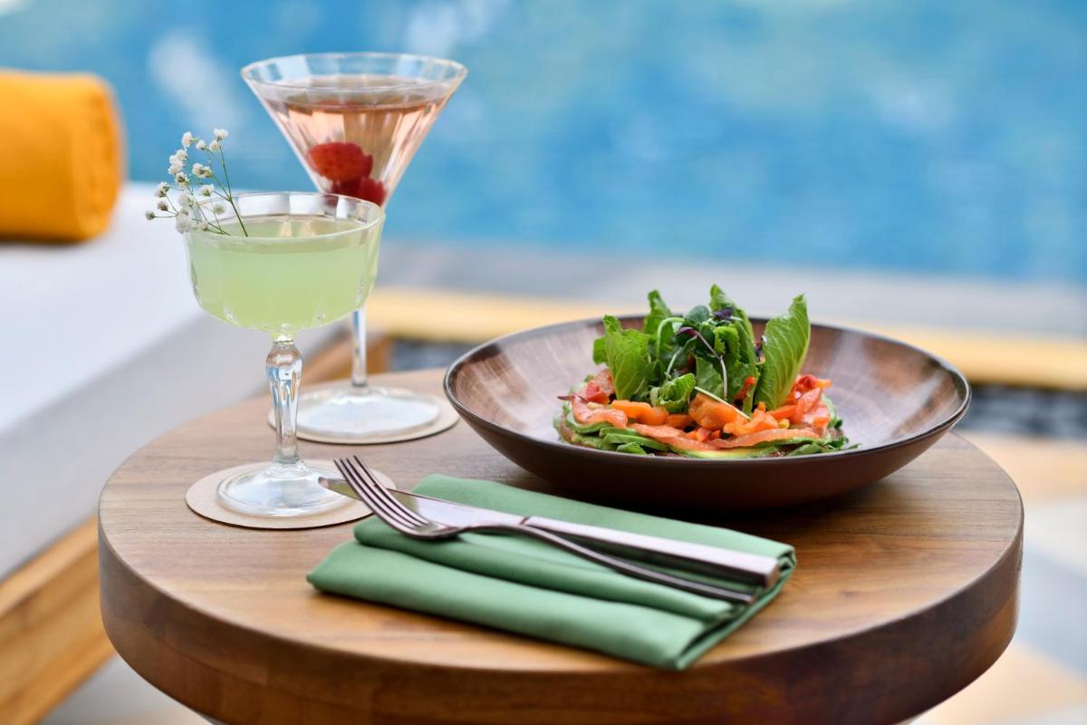 a wooden table with a bowl of salad and a drink at Taj Mahal, New Delhi in New Delhi