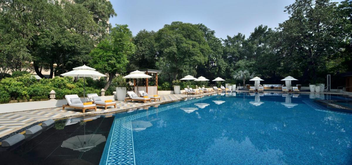 a large swimming pool with lounge chairs and umbrellas at Taj Mahal, New Delhi in New Delhi