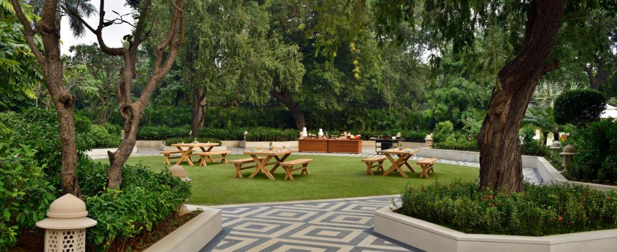 a park with picnic tables and trees and grass at Taj Mahal, New Delhi in New Delhi