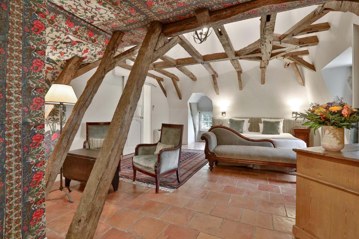 un salon avec deux fauteuils et un lit dans l'établissement Château des Vigiers, à Monestier 51 autres photos