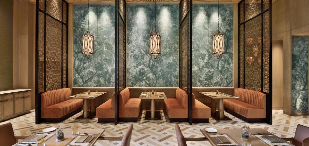a dining room with tables and chairs and chandeliers at Taj Mahal, New Delhi in New Delhi