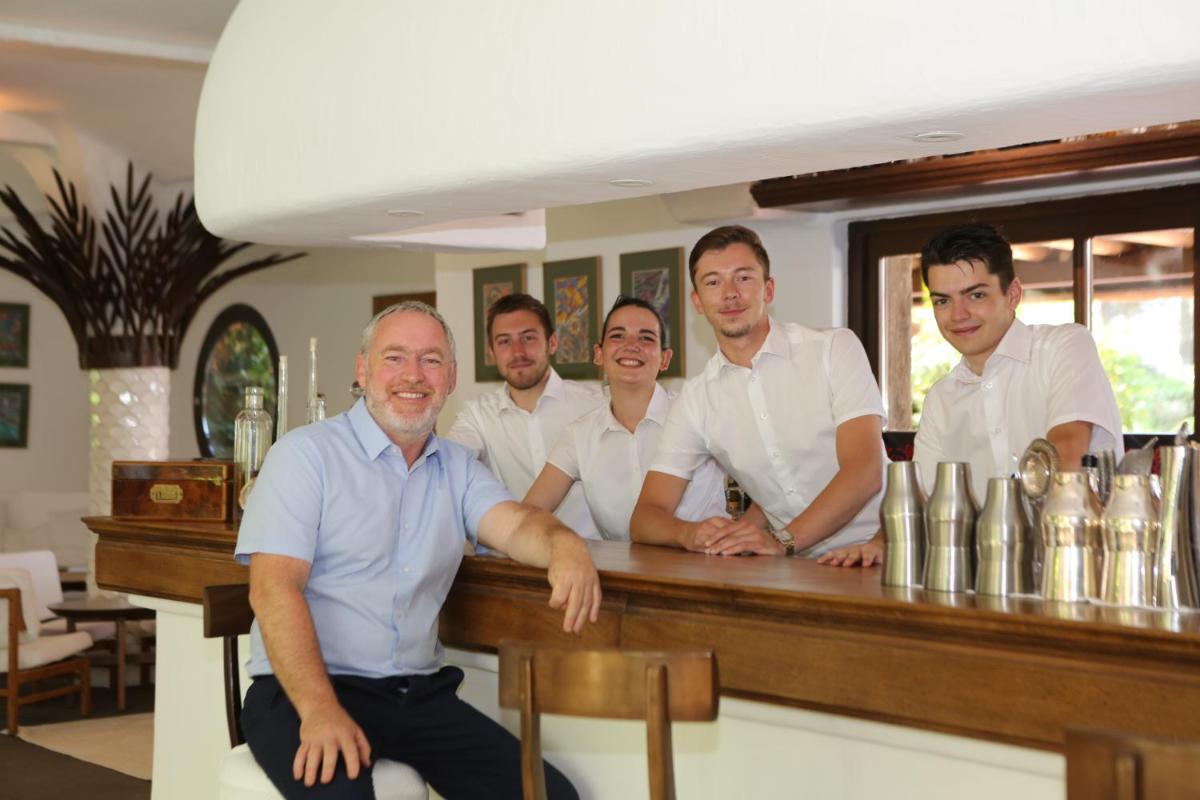 un groupe de personnes debout à un bar dans l'établissement Grand Hôtel De Cala Rossa & Spa Nucca, à Porto-Vecchio 90 autres photos