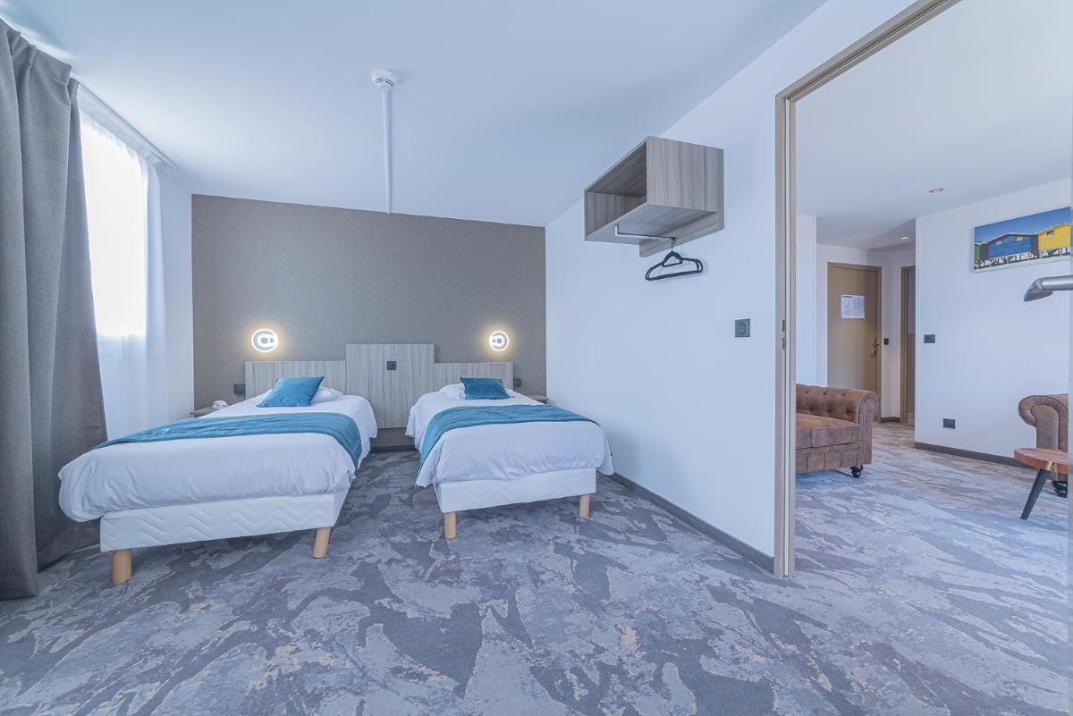 une chambre avec deux lits et un miroir dans l'établissement Relax'Otel & Spa, Le Barcarès, au Barcarès
