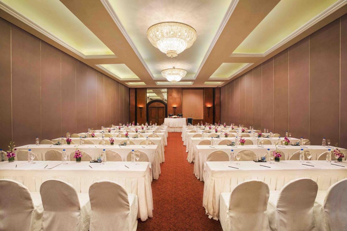 a banquet hall with white tables and chairs at Eros Hotel New Delhi, Nehru Place in New Delhi a banquet hall with white tables and chairs at Eros Hotel New Delhi, Nehru Place in New Delhi