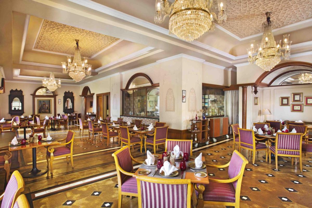a dining room with tables and chairs and chandeliers at Eros Hotel New Delhi, Nehru Place in New Delhi a dining room with tables and chairs and chandeliers at Eros Hotel New Delhi, Nehru Place in New Delhi