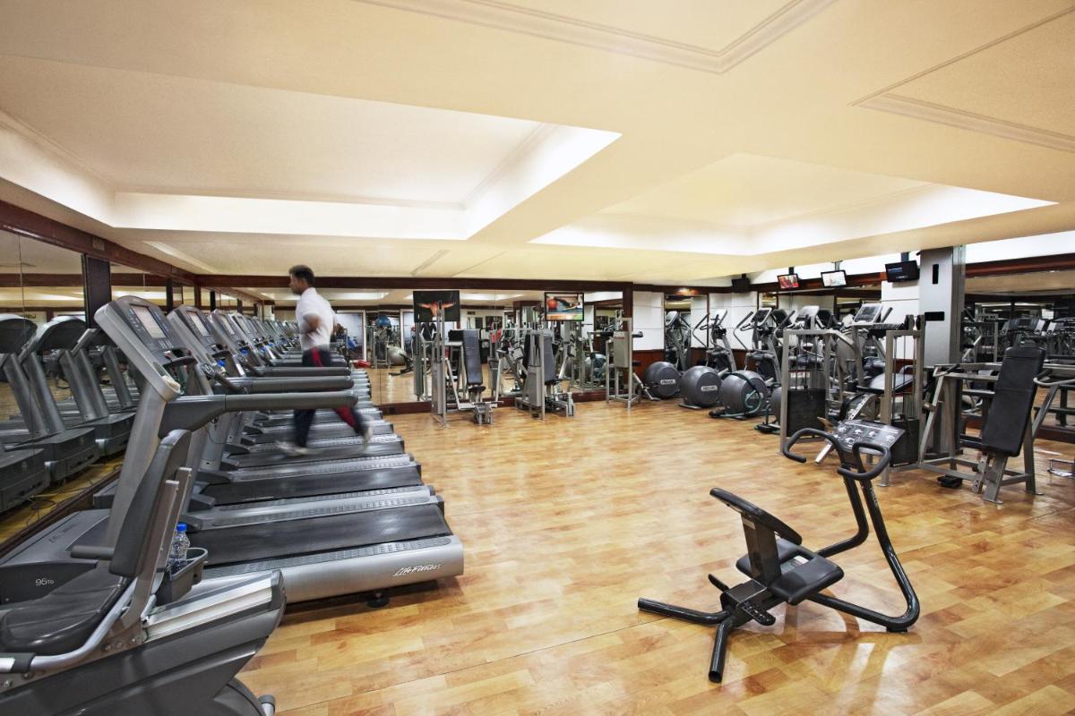 a man walking through a gym with treadles at Eros Hotel New Delhi, Nehru Place in New Delhi a man walking through a gym with treadles at Eros Hotel New Delhi, Nehru Place in New Delhi
