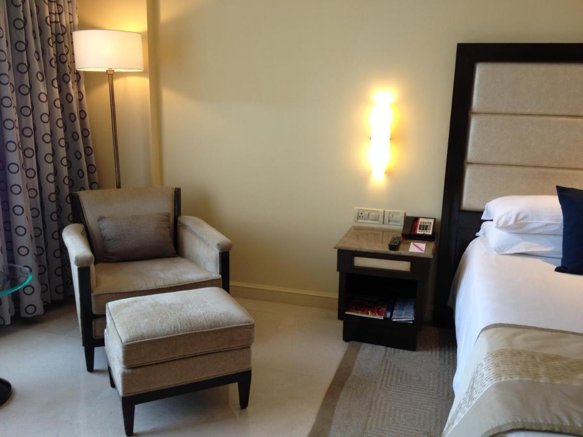 a hotel room with a chair and a bed and a chair at Blue Diamond Pune IHCL SeleQtions in Pune