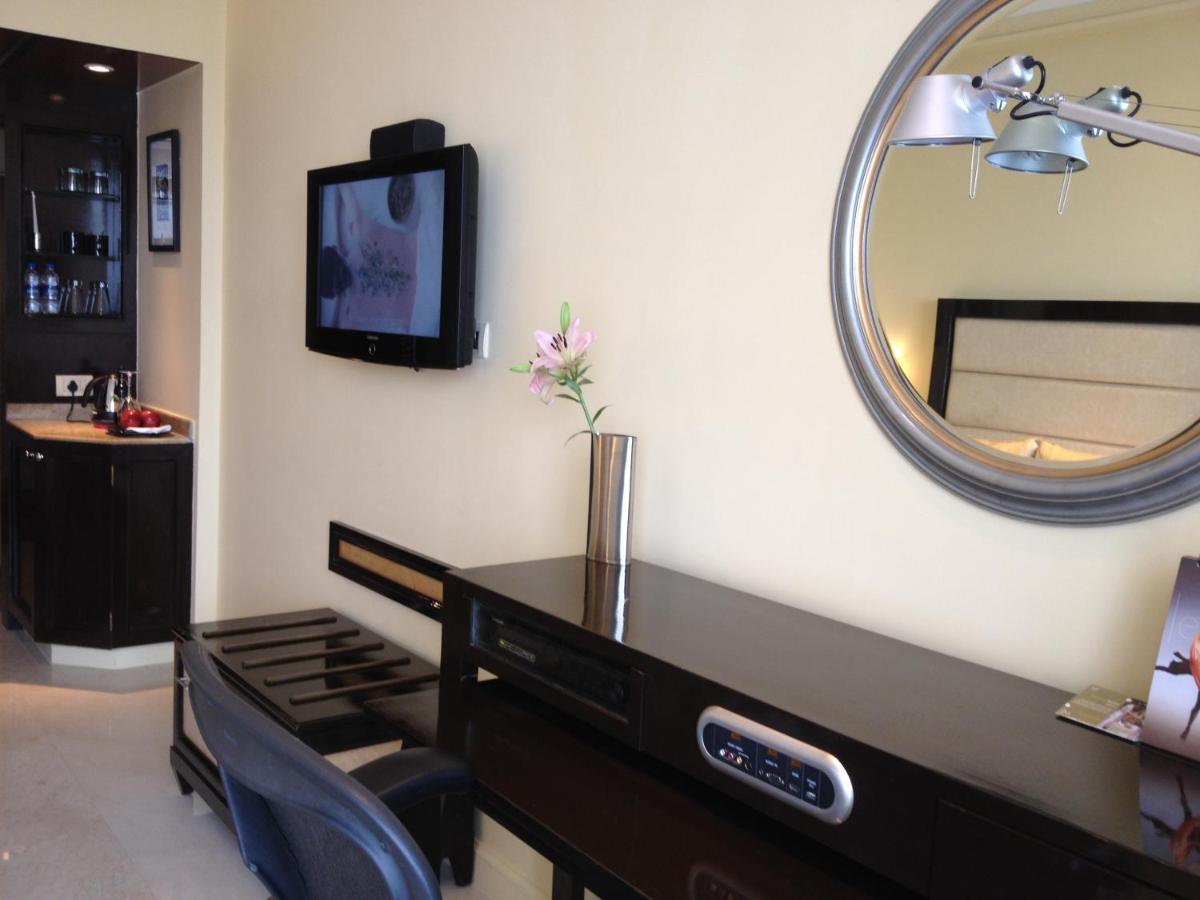 a bathroom with a vanity and a mirror on the wall at Blue Diamond Pune IHCL SeleQtions in Pune