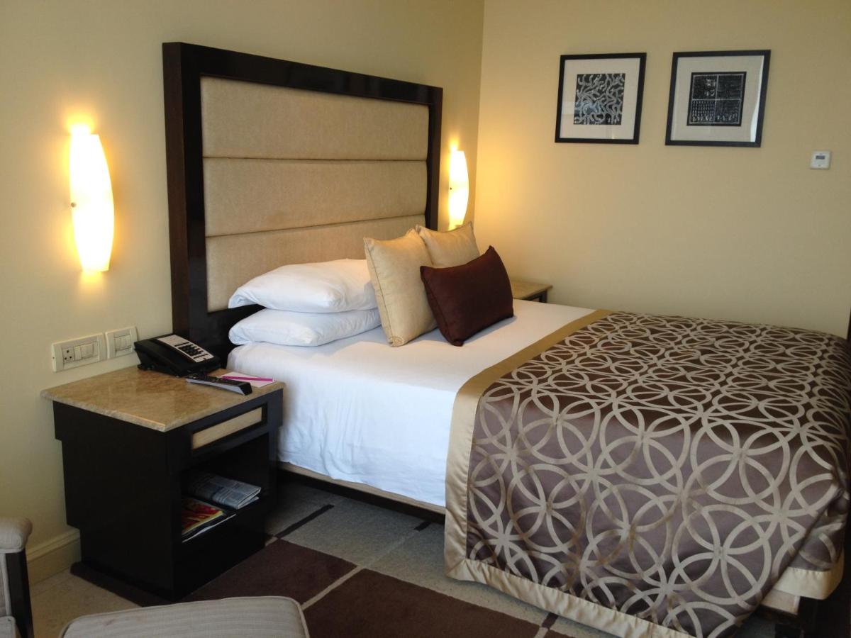 a hotel room with a large bed and a phone at Blue Diamond Pune IHCL SeleQtions in Pune
