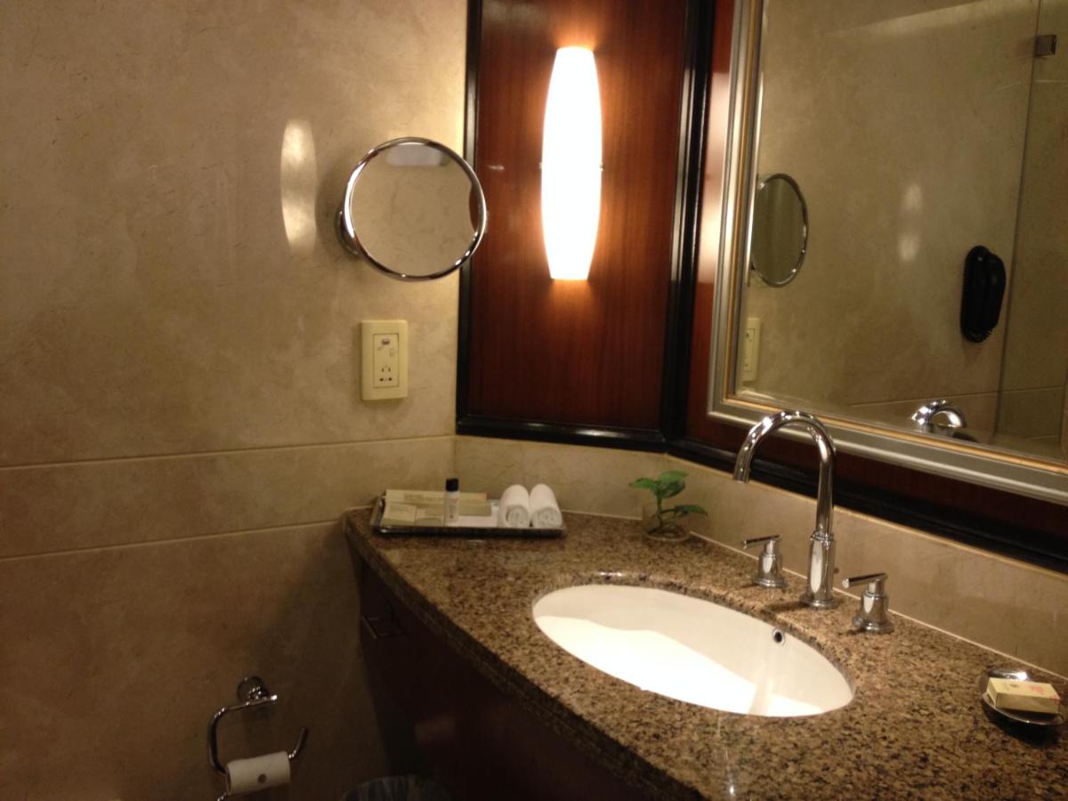 a bathroom with a sink and a mirror at Blue Diamond Pune IHCL SeleQtions in Pune