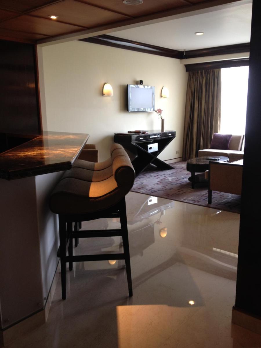 a living room with a table and a chair at Blue Diamond Pune IHCL SeleQtions in Pune