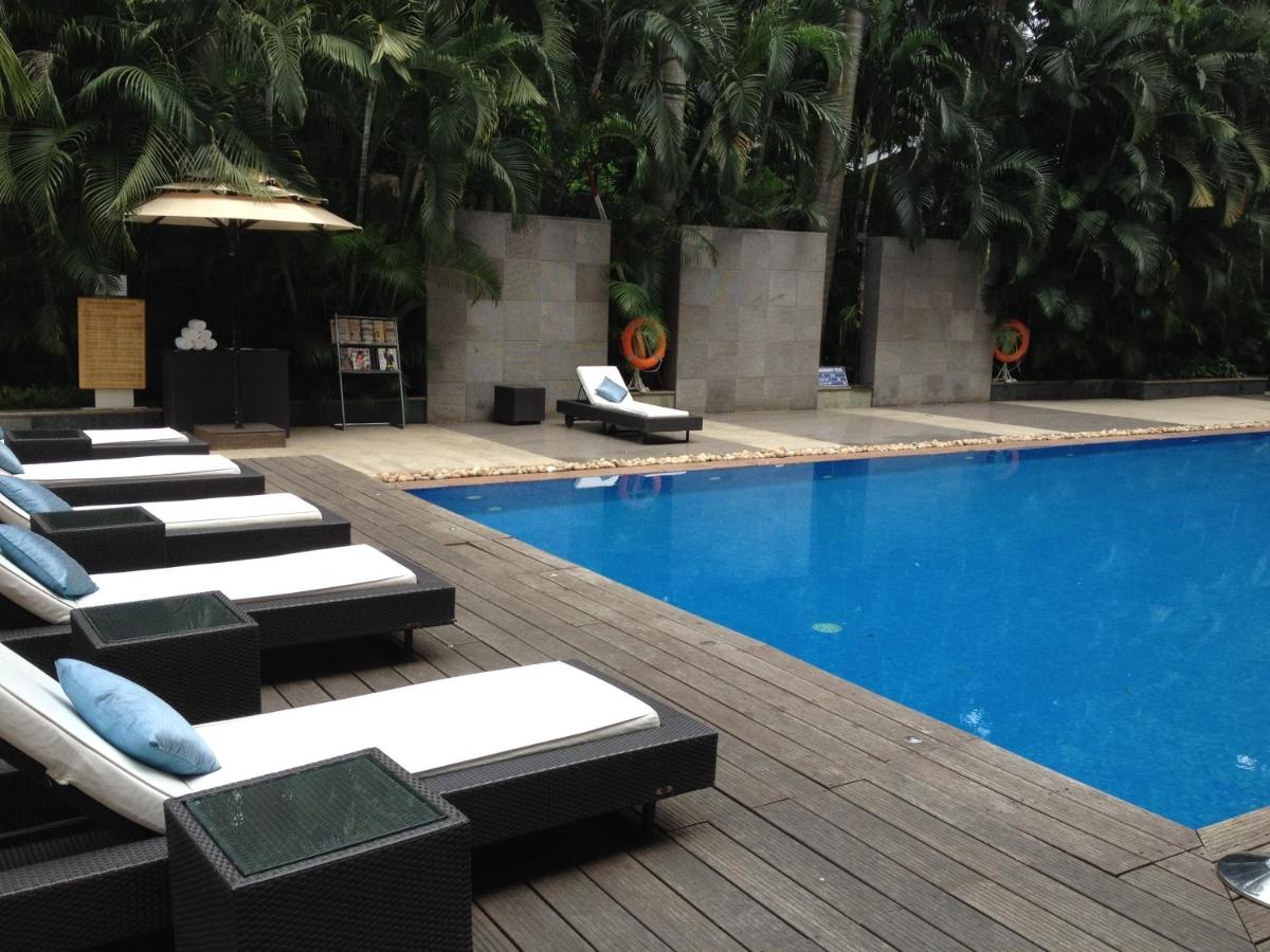 a swimming pool with chaise lounge chairs next to it at Blue Diamond Pune IHCL SeleQtions in Pune