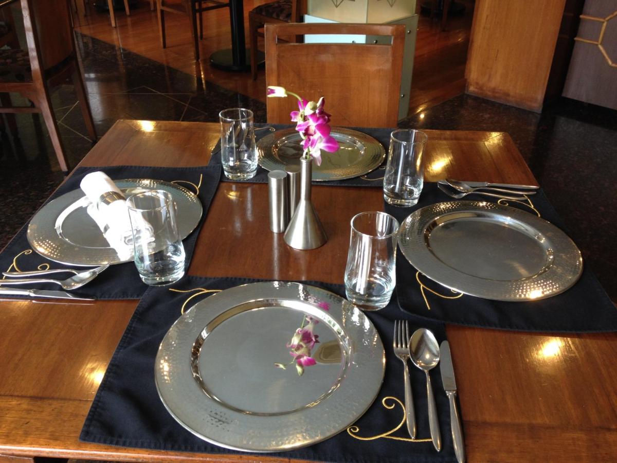 a wooden table with plates and utensils on it at Blue Diamond Pune IHCL SeleQtions in Pune