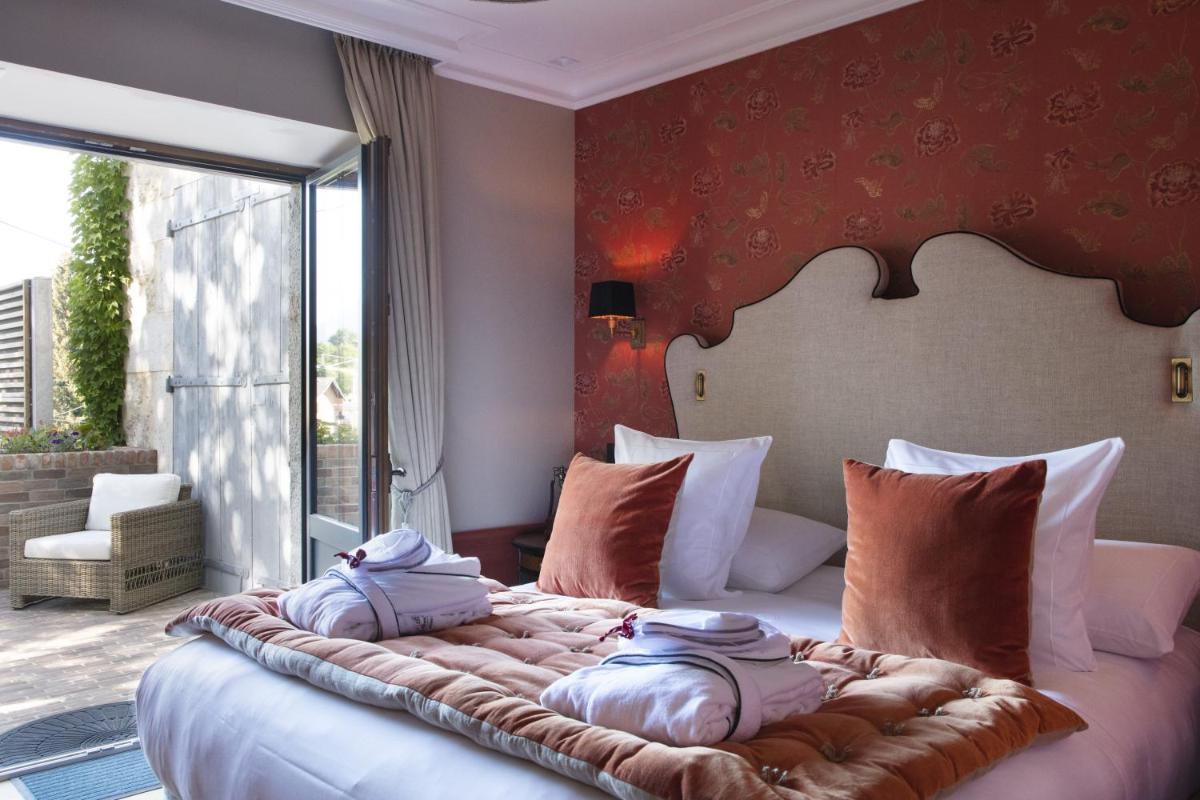 une chambre avec un grand lit avec des oreillers dessus dans l'établissement Château Brachet, à Grésy-sur-Aix 27 autres photos