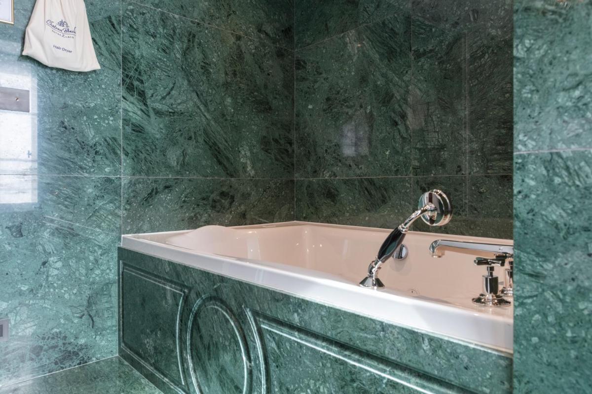La salle de bains en marbre vert est pourvue d'une baignoire. dans l'établissement Château Brachet, à Grésy-sur-Aix