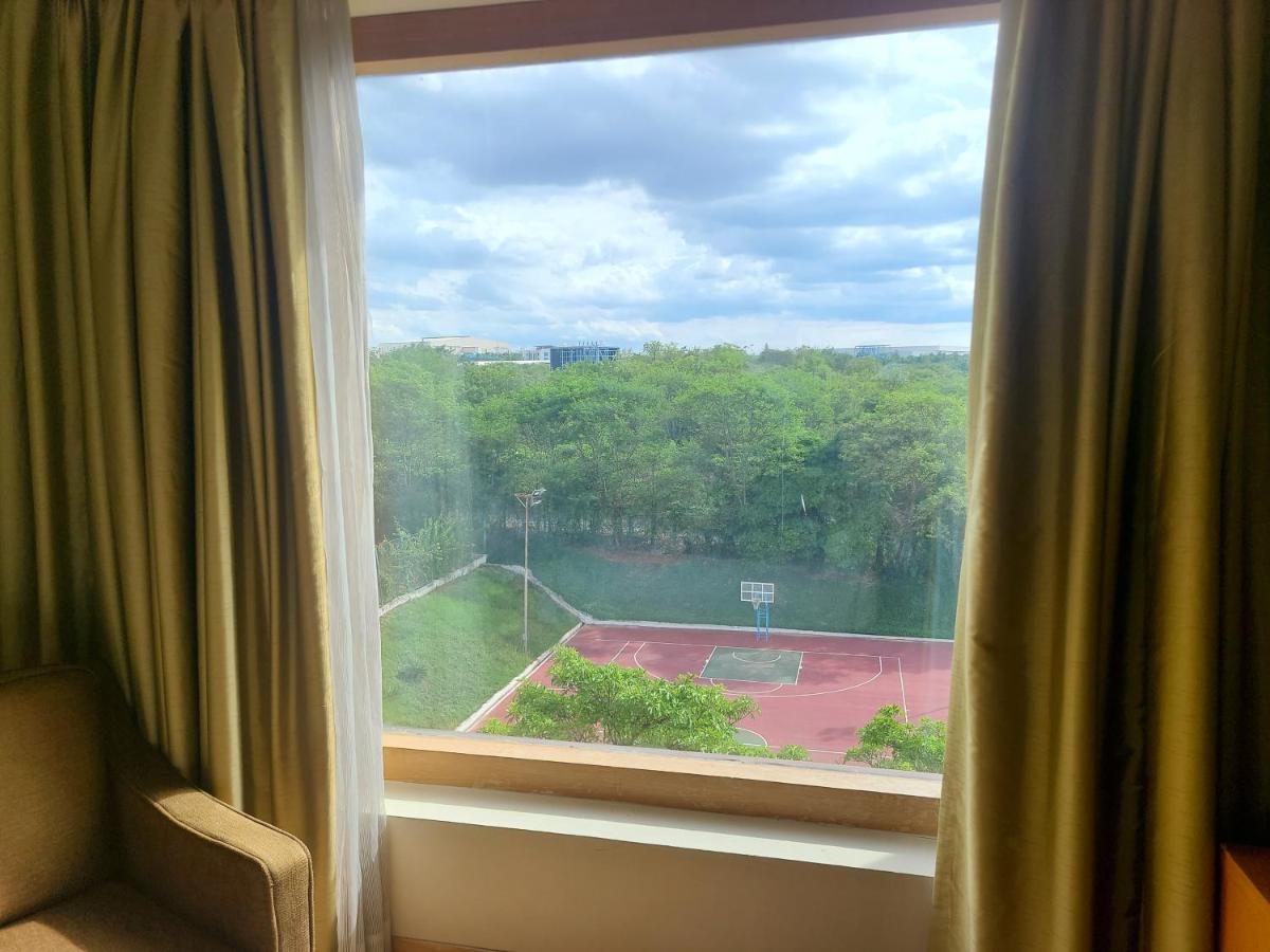 a window with a view of a tennis court at Novotel Hyderabad Airport in Hyderabad