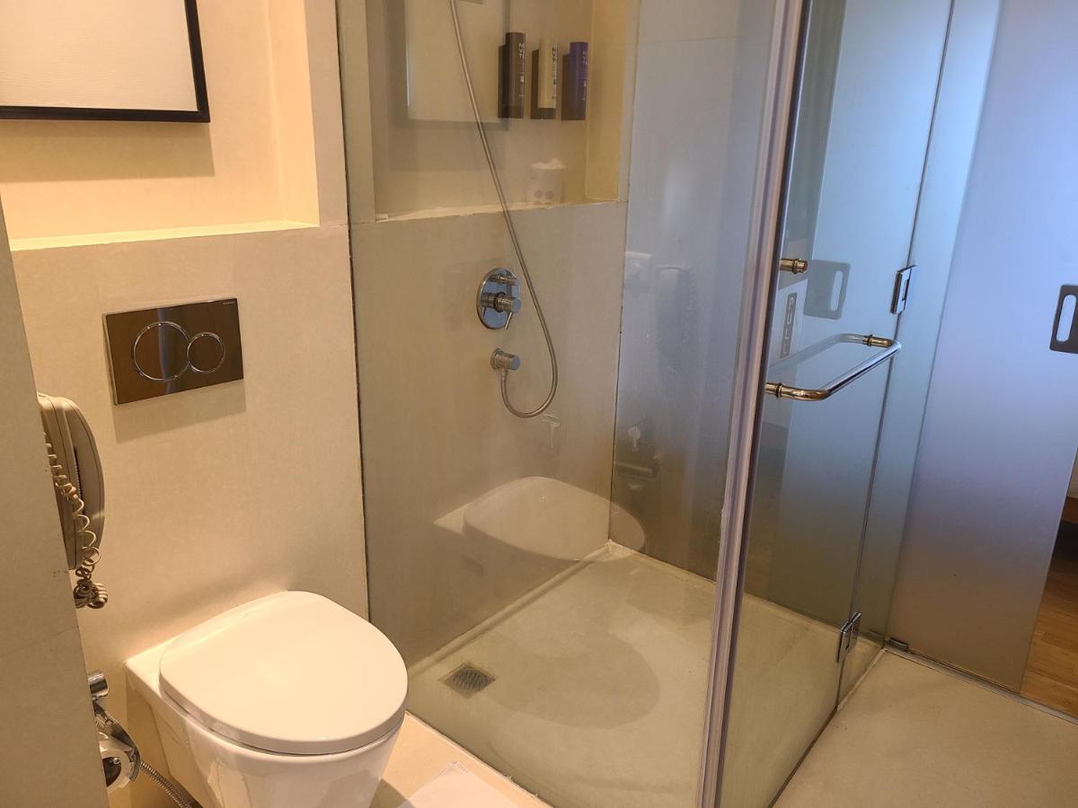 a bathroom with a shower and a toilet at Novotel Hyderabad Airport in Hyderabad