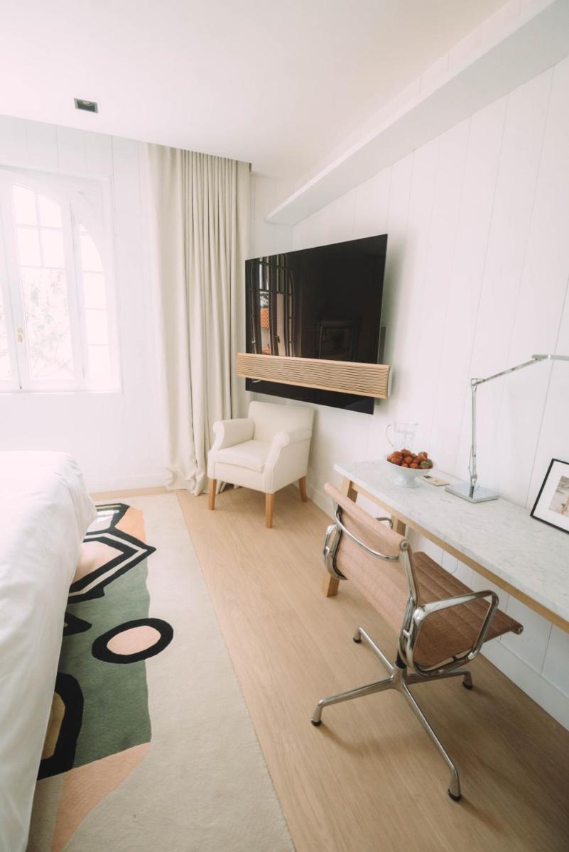 - un salon blanc avec un bureau et une chaise dans l'établissement Hôtel Hemen, à Saint-Palais-sur-Mer