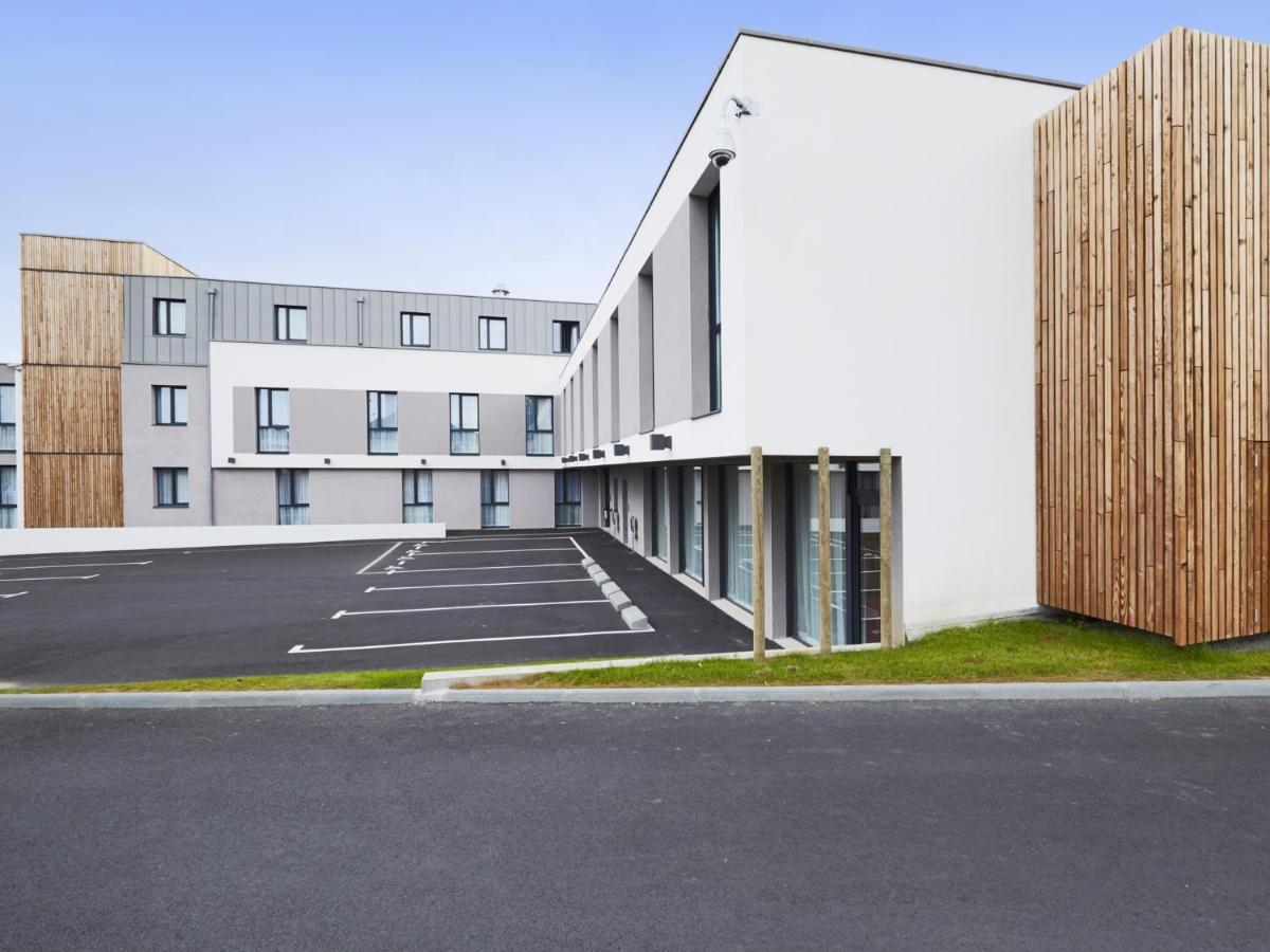 un parking vide devant un immeuble dans l'établissement Kyriad Prestige Saint-Malo, à Saint-Malo