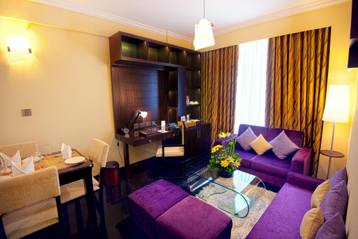 a living room with a purple couch and a table at Sterlings Mac Hotel in Bengaluru