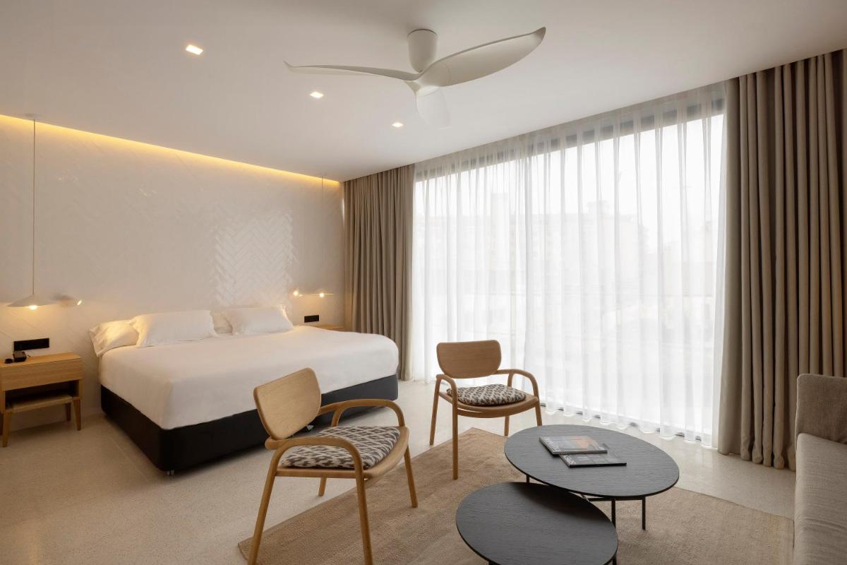 Una habitación de hotel con una cama, una mesa y sillas. en HM Palma Blanc, en Palma de Mallorca
