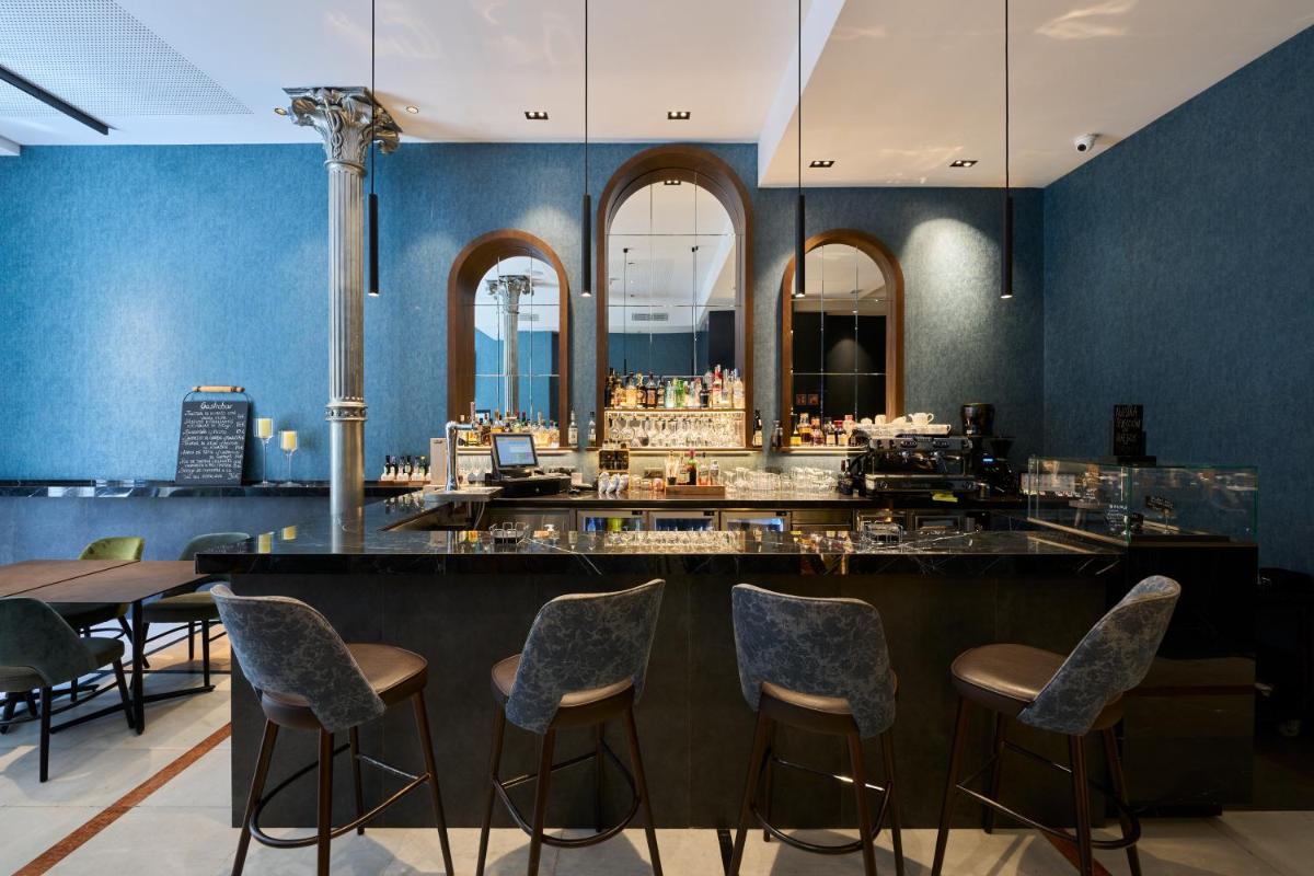 un bar en un restaurante con paredes y sillas azules en Catalonia Plaza Catalunya, en Barcelona