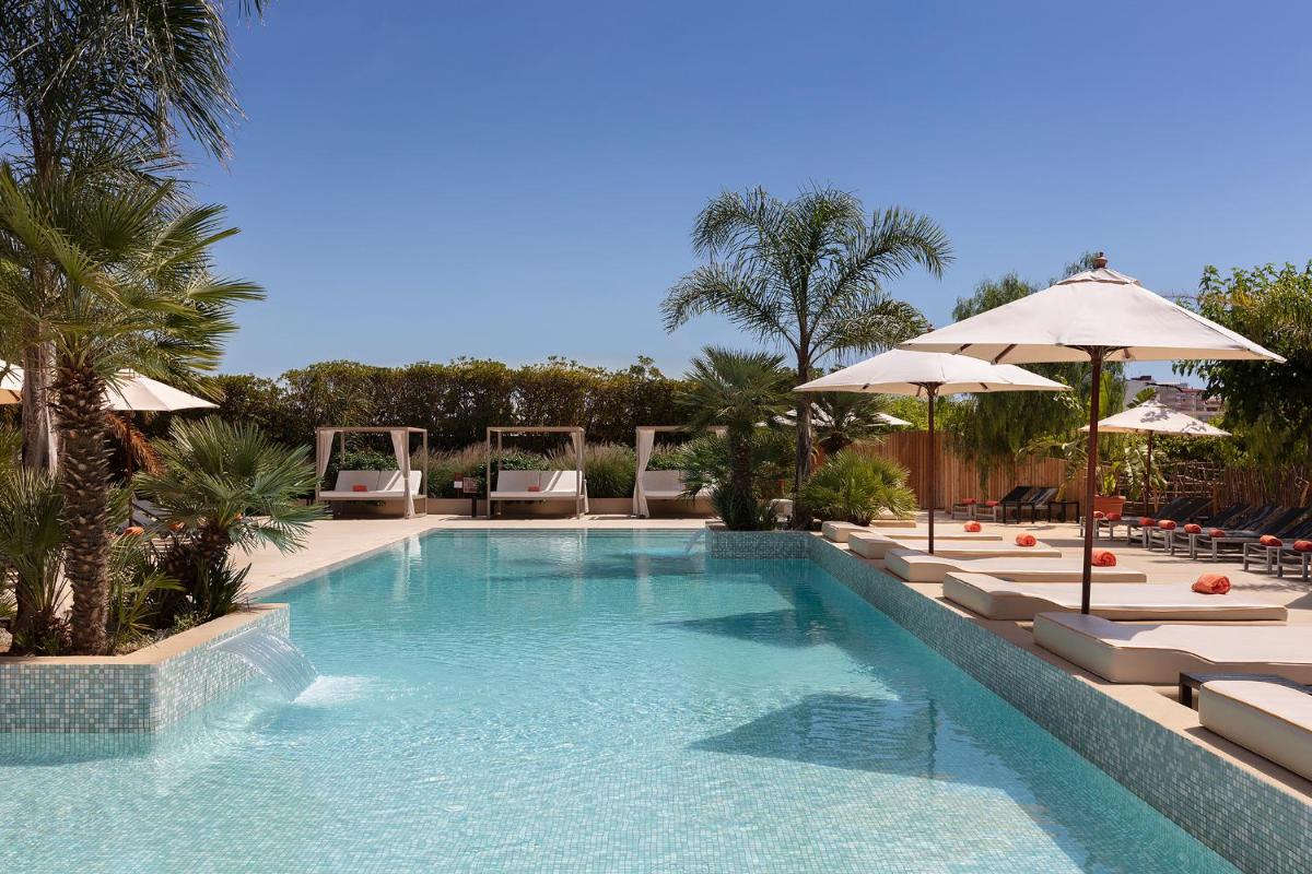 una gran piscina con sillas y sombrillas en Luna Club Hotel Yoga & Spa 4Sup, en Malgrat de Mar una gran piscina con sillas y sombrillas en Luna Club Hotel Yoga & Spa 4Sup, en Malgrat de Mar