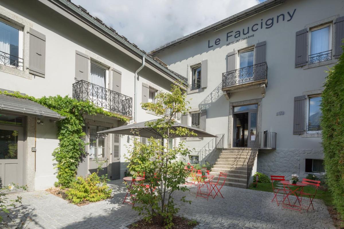 un bâtiment avec un parasol devant lui dans l'établissement Le Faucigny - Hotel de Charme & SPA, à Chamonix-Mont-Blanc