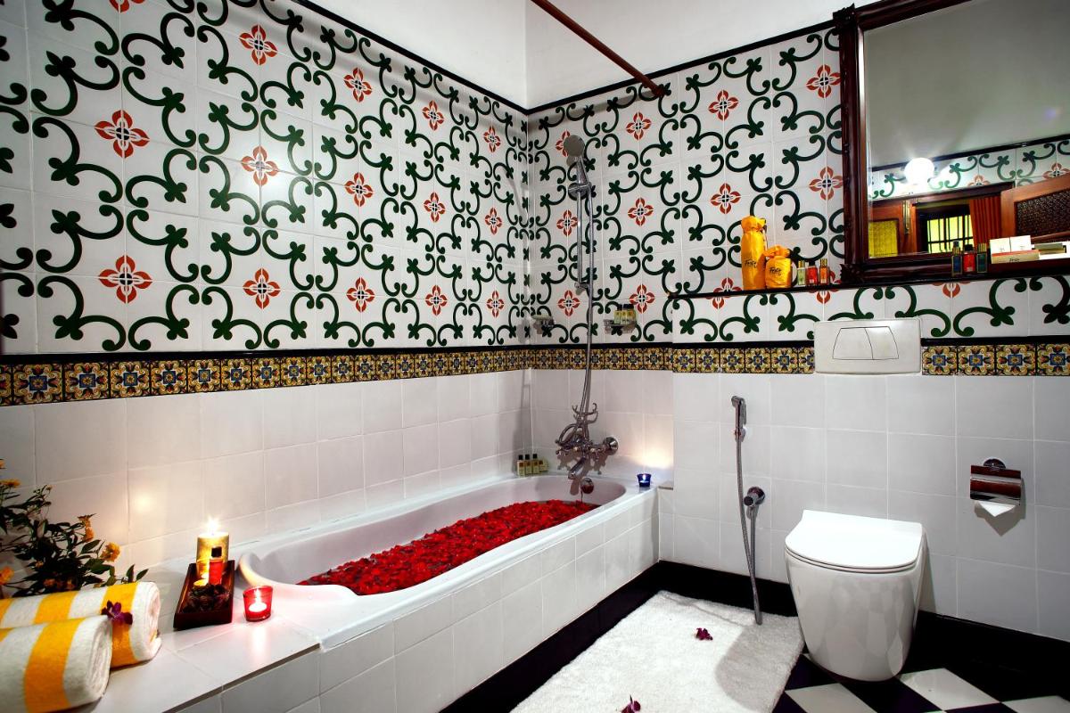 a bathroom with a tub filled with red roses at Forte Kochi in Cochin +31 photos