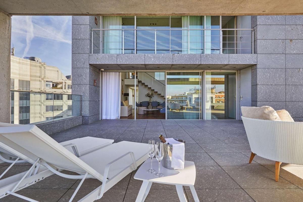 Un patio con sillas y mesas y un edificio. en Hyatt Regency Madrid Residences, en Madrid