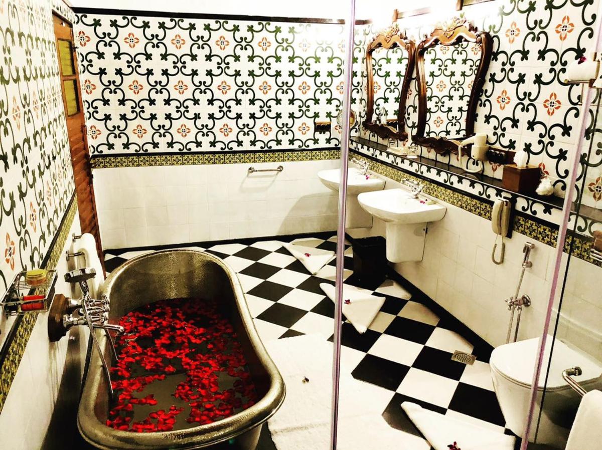 a bathroom with a bath tub filled with red roses at Forte Kochi in Cochin