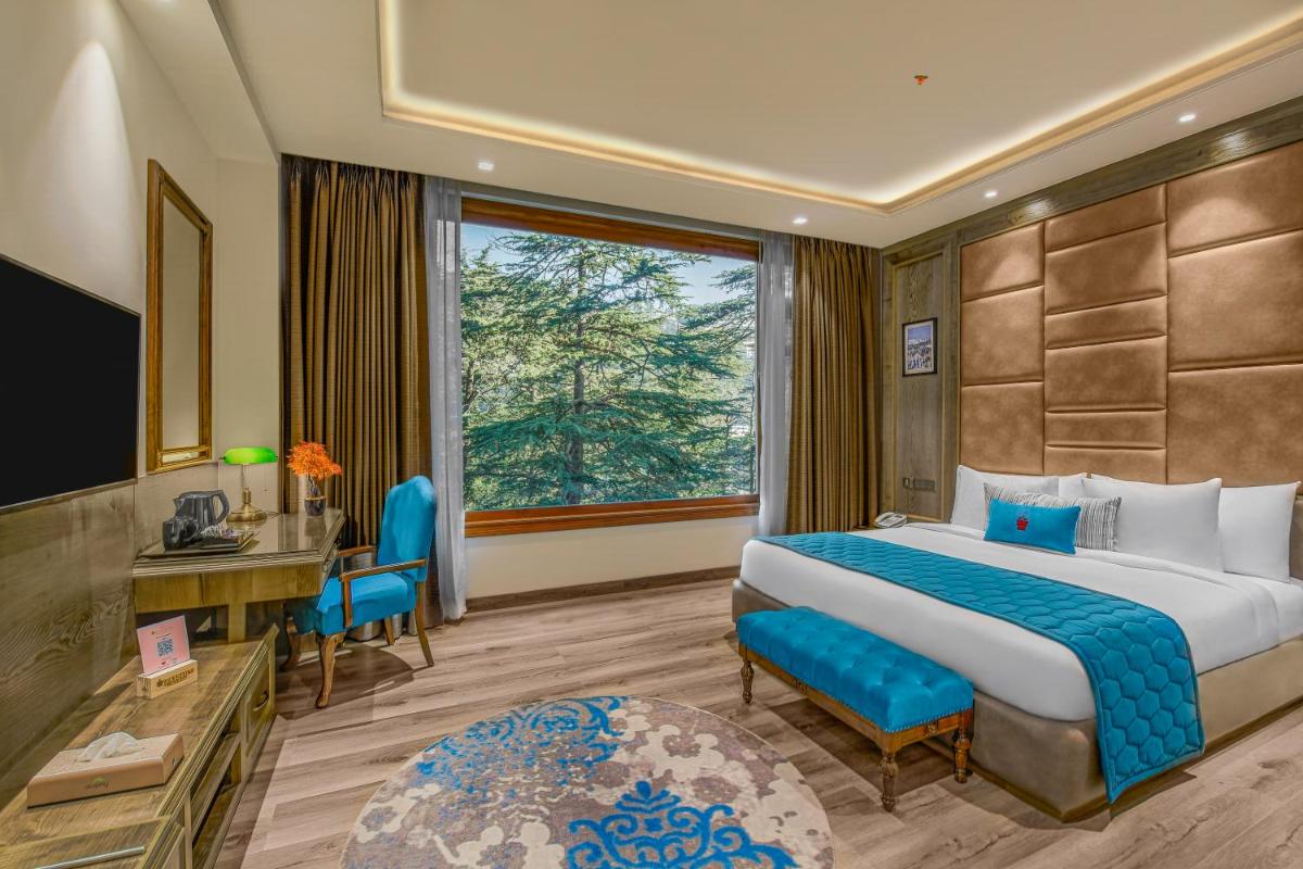 a hotel room with a bed and a window at WelcomHeritage Elysium Resort & Spa in Shimla