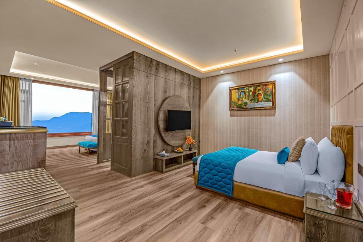 a hotel room with a bed and a television at WelcomHeritage Elysium Resort & Spa in Shimla