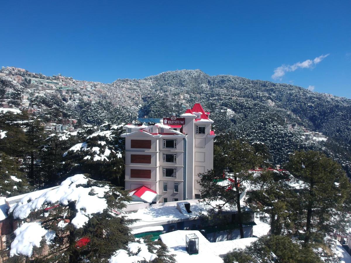 a white building with a red roof in the snow at WelcomHeritage Elysium Resort & Spa in Shimla