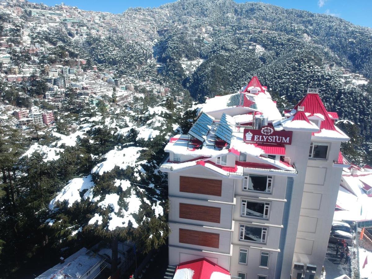 a white building with a red roof on a mountain at WelcomHeritage Elysium Resort & Spa in Shimla