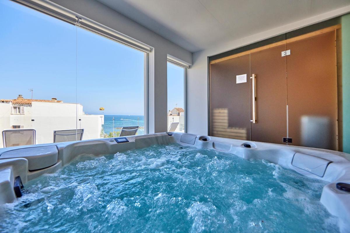 bañera de hidromasaje en una habitación con vistas al océano en Hotel Ilusion Moreyo - Adults Only, en Cala Bona