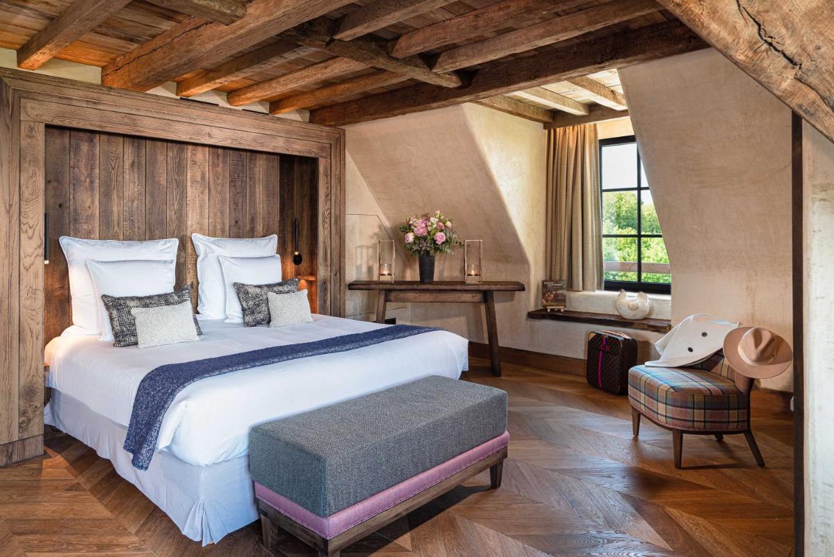 une chambre avec un grand lit blanc et une fenêtre dans l'établissement La Ferme Saint Simeon Spa - Relais & Chateaux, à Honfleur une chambre avec un grand lit blanc et une fenêtre dans l'établissement La Ferme Saint Simeon Spa - Relais & Chateaux, à Honfleur