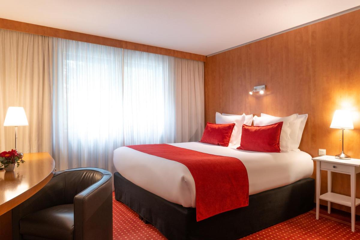 une chambre d'hôtel avec un grand lit avec des oreillers rouges dans l'établissement Le M & Spa Bordeaux Aéroport by Hôtels & Préférence, à Mérignac 42 autres photos
