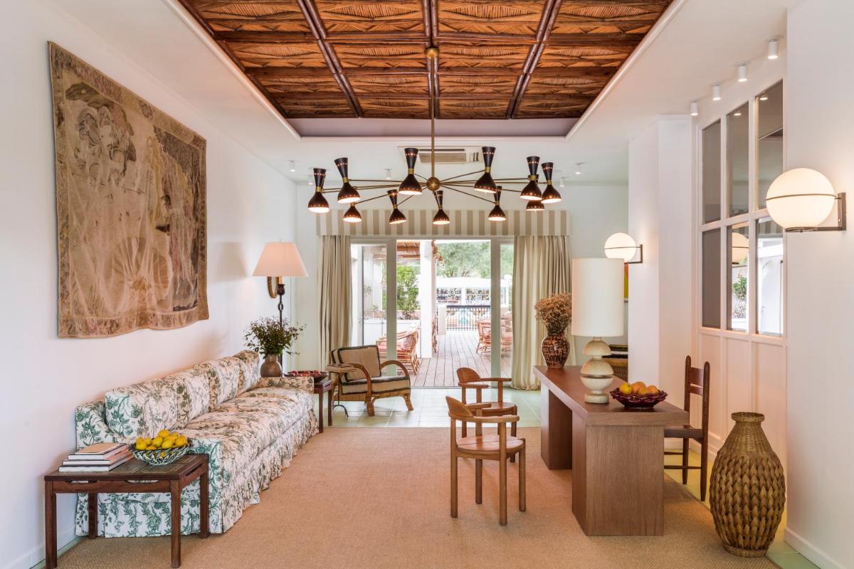 un salon avec un canapé et une table dans l'établissement Hôtel La Tartane Saint-Tropez, à Saint-Tropez