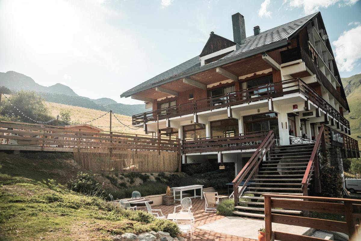 une grande maison avec une terrasse et des escaliers sur une colline dans l'établissement Les Cèdres - Hôtel - Restaurants - Spa, à Saint-Sorlin-dʼArves