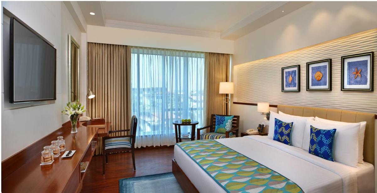 a hotel room with a bed and a desk and a television at Fortune Miramar, Goa - Member ITC Hotels' Group in Panaji a hotel room with a bed and a desk and a television at Fortune Miramar, Goa - Member ITC Hotels' Group in Panaji