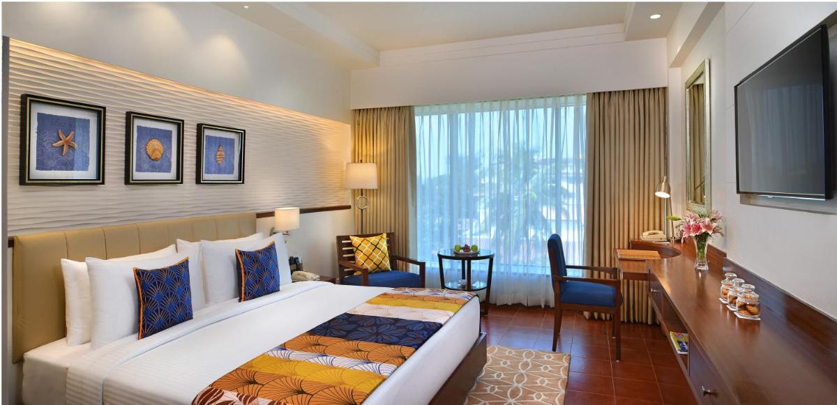 a hotel room with a large bed and a desk at Fortune Miramar, Goa - Member ITC Hotels' Group in Panaji a hotel room with a large bed and a desk at Fortune Miramar, Goa - Member ITC Hotels' Group in Panaji